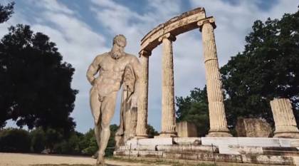 The video contains many images of ancient gods superimposed on archaeological sites. Here, Hercules stands in Olympia